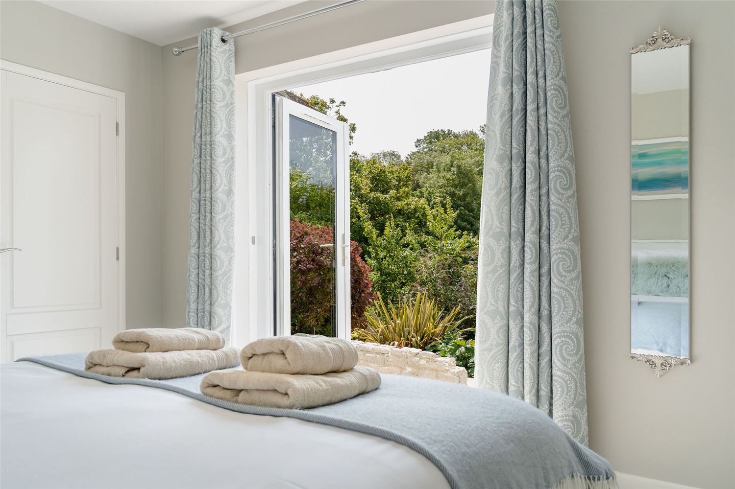 Master bedroom king bed with french doors opening to the garden