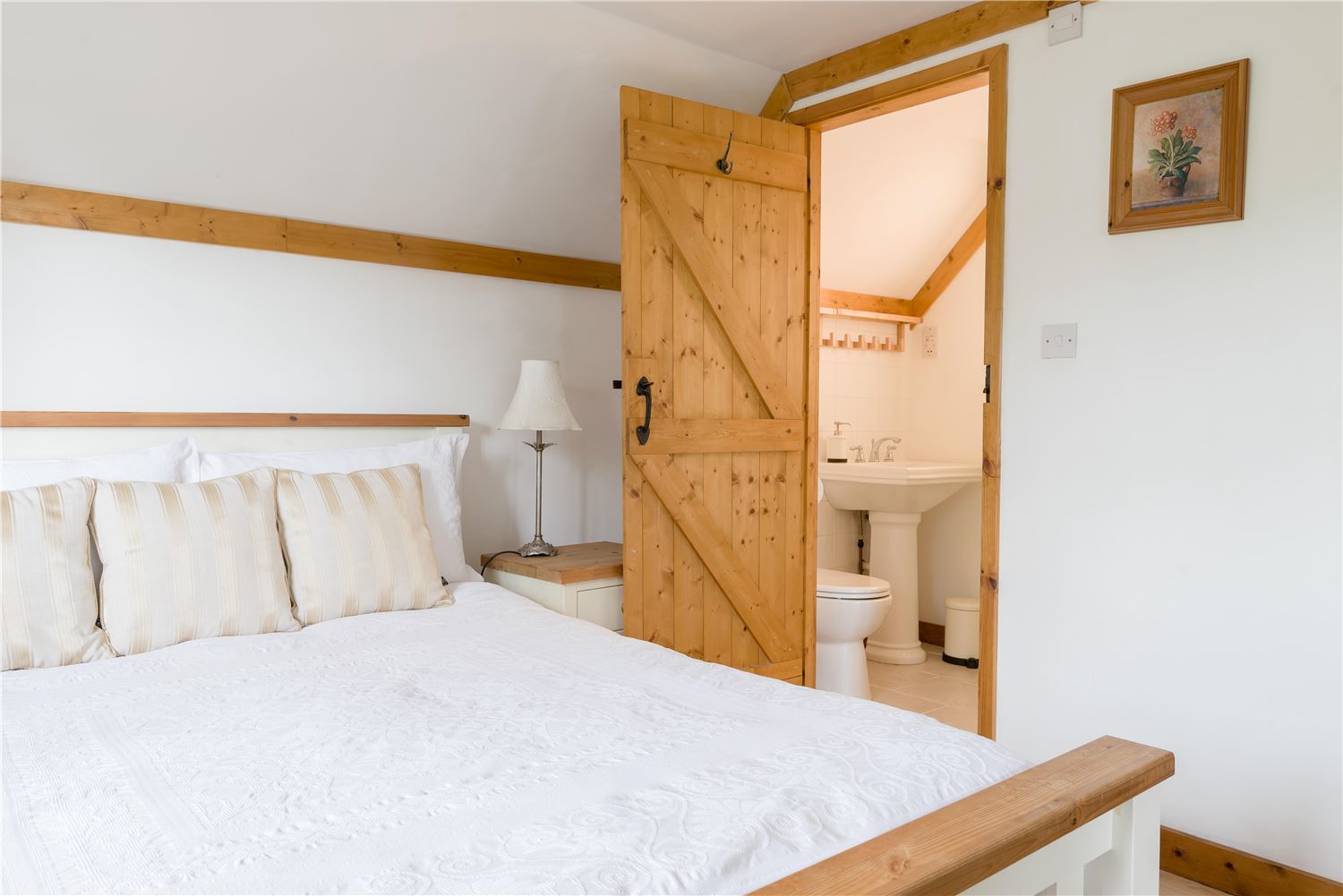 Master bedroom withthe double-aspect master bedroom features a king-size bed with luxurious linen, ample storage, a TV, and a private en-suite with an overhead rain shower. ensuite